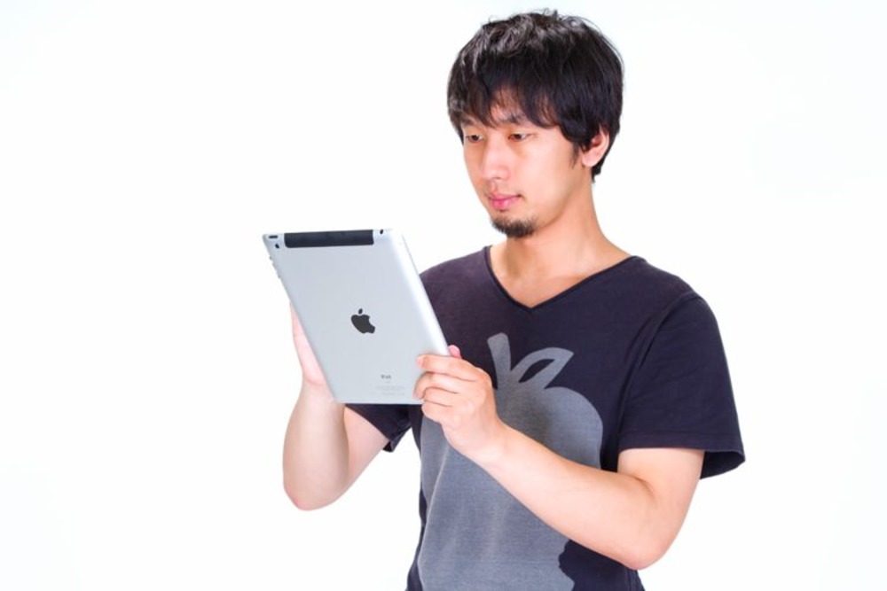 タブレットをいじる男性